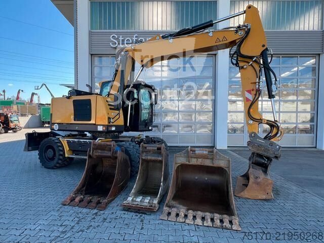 Použitý vykopávač kol Hydrema MX14G / OilQuick OQ65 / 4x lžička / 2.343h / 2022